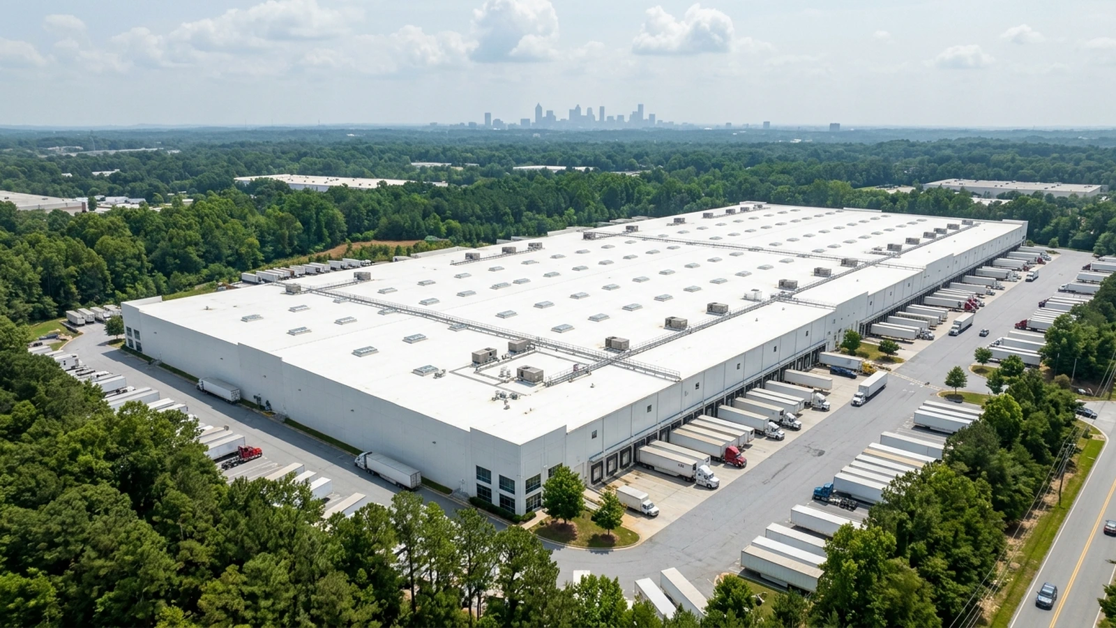 Aerial view of an industrial flat-roof warehouse in Atlanta with skylights and solar array mounts